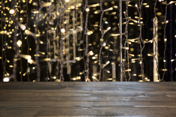 模糊的金色花环和木制桌面前景。图片展示或蒙太奇您的圣诞产品。图片下载