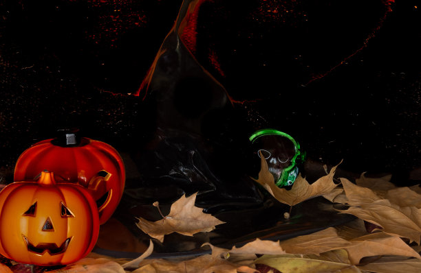 女巫帽，南瓜头骨和干树叶，黑色和橙色的背景图片下载
