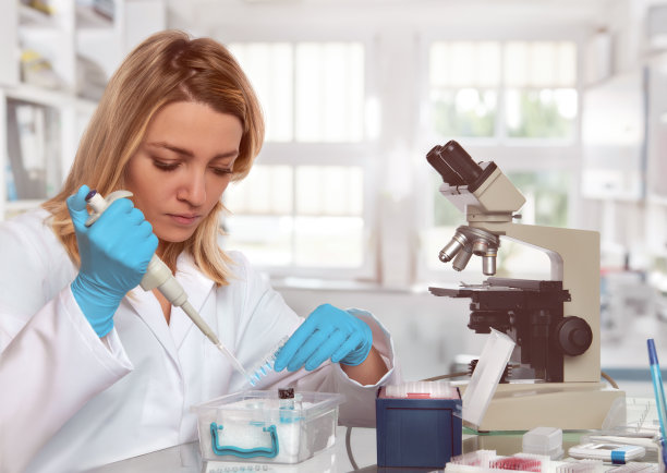 年轻女技术员或科学家将液体样本装入试管素材图片