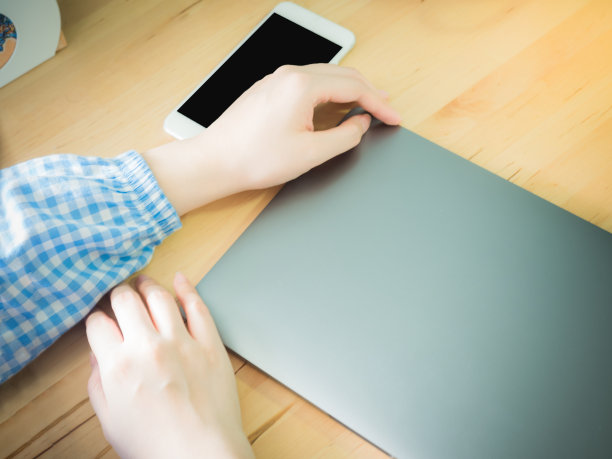 现代灰色的电脑、笔记本电脑和手机和亚洲商务女性的手放在木制的工作台上图片下载