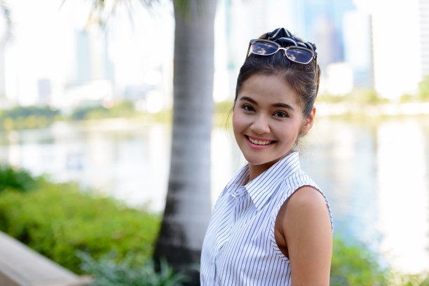 年轻美丽的亚洲女人在泰国曼谷的公园放松图片下载