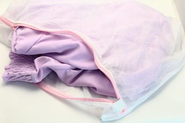 为了防止洗好的衣物损坏，把它放在网眼袋里清洗。图片下载