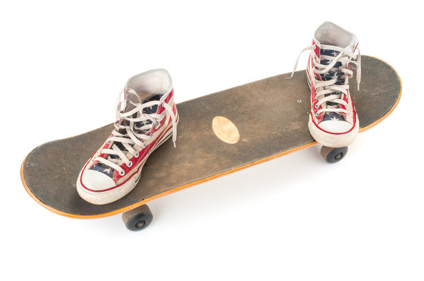 白色背景上的旧滑板和侦探鞋图片下载