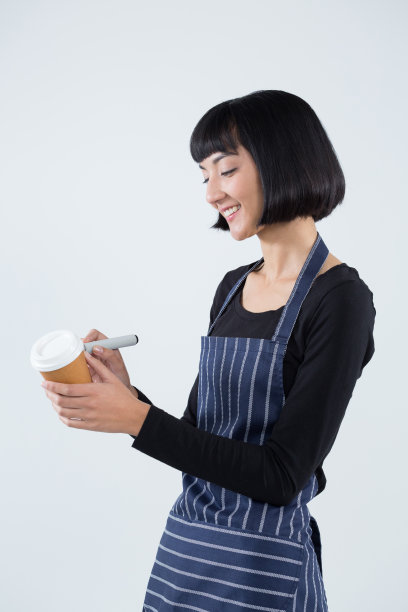 微笑的女服务员在一次性咖啡杯上写字图片下载