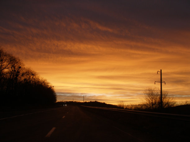 在夕阳的余晖中，汽车行驶在轨道上图片下载