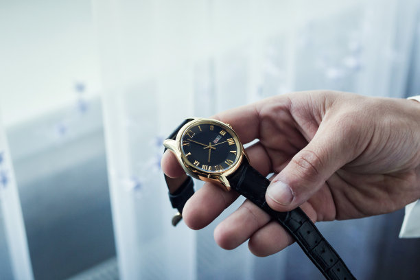 商人时钟衣服，商人检查他的手表时间。男人的手上有手表，男人的手上有手表，新郎的费用，准备工作，把钟表放在手上，固定钟表的时间，男人的风格图片下载