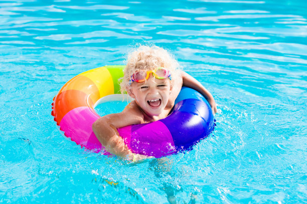 游泳池里带着玩具圈的孩子图片下载
