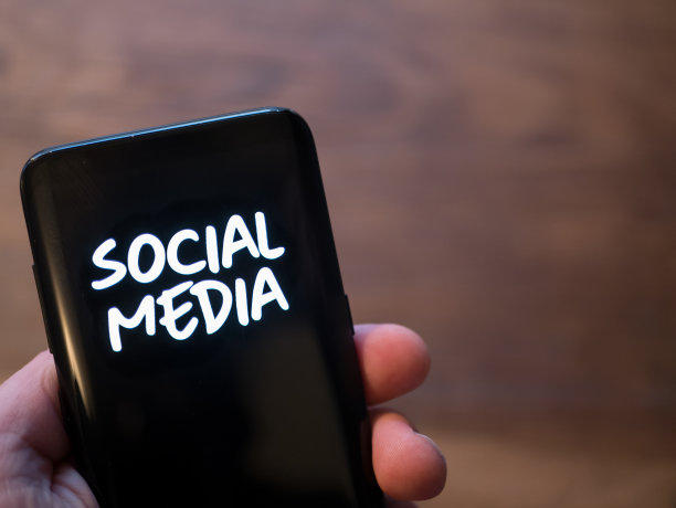 手机显示器显示文本社交媒体在黑白颜色。手持智能手机的概念。图片下载