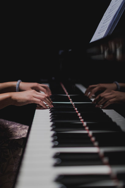 女钢琴家的手在钢琴键盘上。图片下载