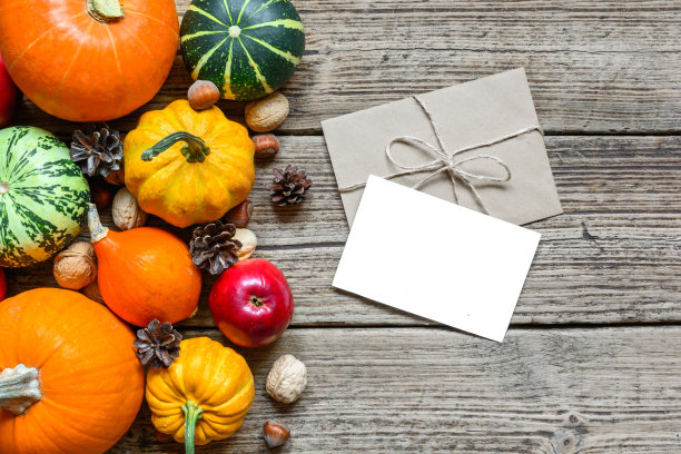 空白贺卡和信封与感恩节秋天的背景，在框架收获的南瓜，苹果，坚果和枫叶图片下载