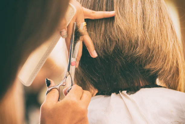 理发师用手剪头发。素材图片