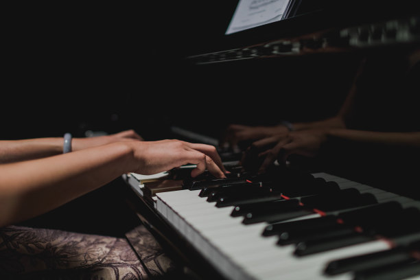 女钢琴家的手在钢琴键盘上。图片下载