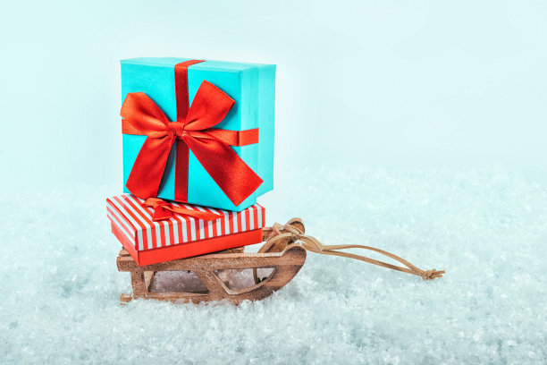 在雪地上用礼物拉雪橇。图片下载