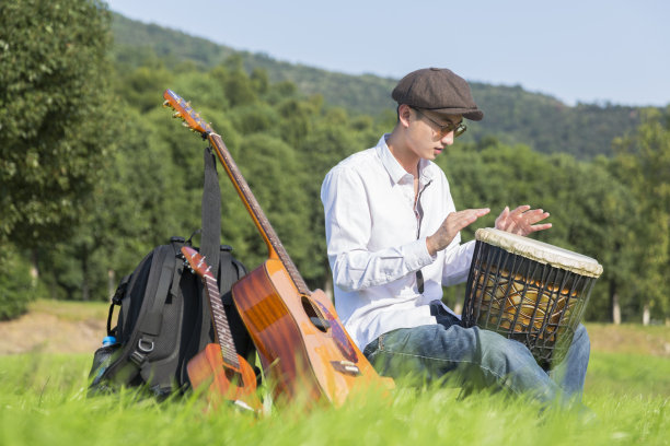 一个年轻人在一个阳光明媚的日子里敲着手鼓图片下载