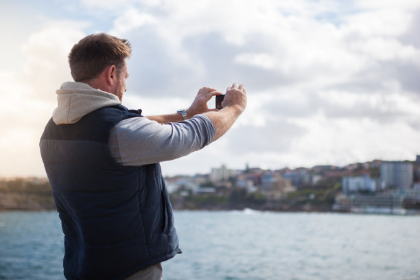 一个成熟的男人在他下午海边散步时拍下了海岸景色的照片图片下载