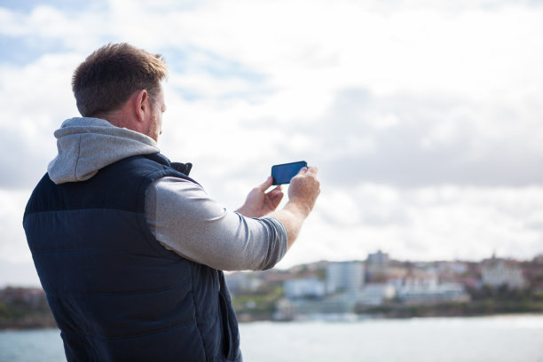 一个成熟的男人在他下午海边散步时拍下了海岸景色的照片图片下载