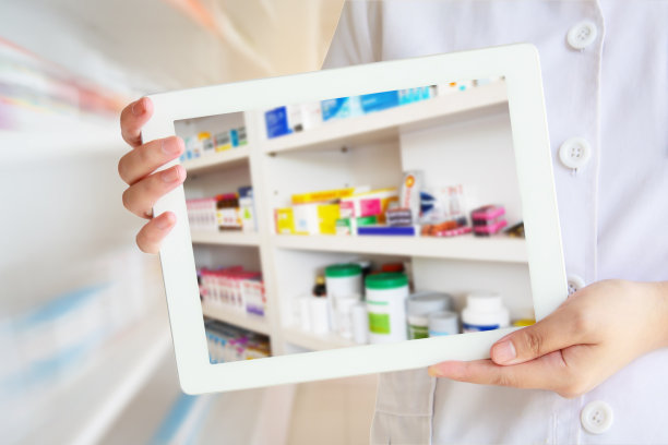 药剂师在药房背景前展示平板电脑图片下载