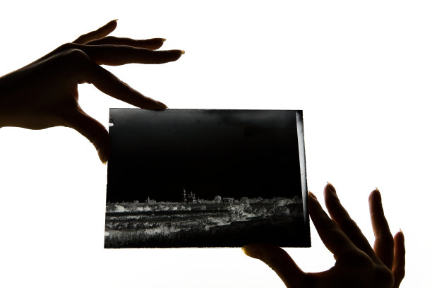 美丽的女性手指拿着一个玻璃底片。图片下载