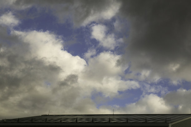 蓝色的天空，屋顶上有白色的积云图片下载