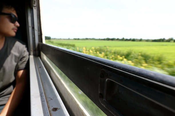 选择性聚焦和浅景深。模糊的年轻时髦的亚洲游客从火车的窗口看自然景观。图片下载