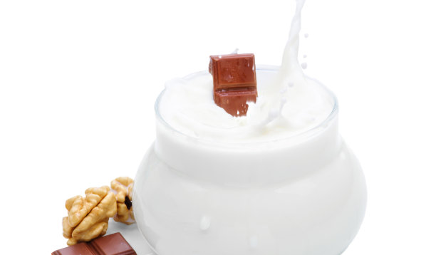 一杯牛奶，坚果和一块巧克力。巧克力掉进牛奶里。白色背景上的孤立照片图片下载