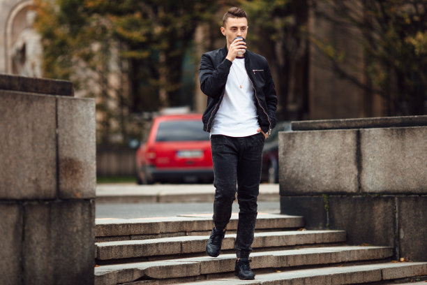 一个人走在街上，手里拿着一杯咖啡图片下载