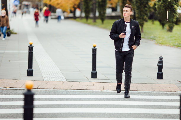 一个人走在街上，手里拿着一杯咖啡图片下载