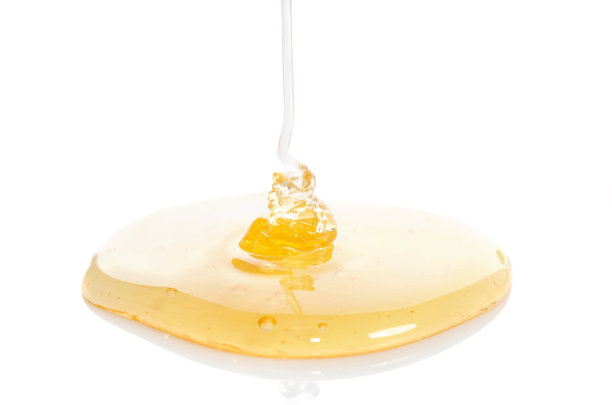 将蜂蜜倒在白色的背景上图片下载