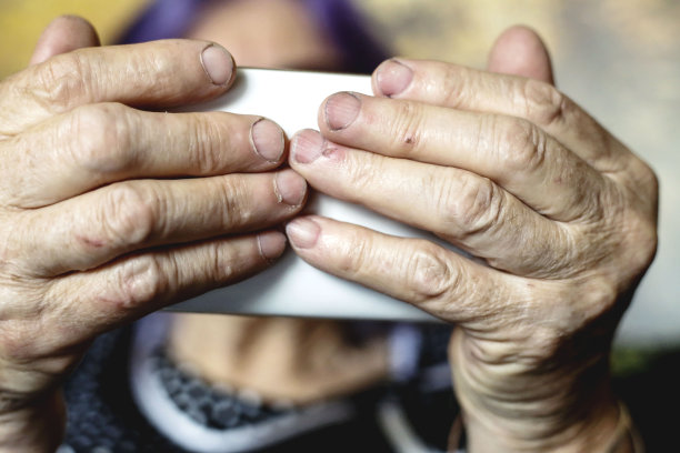 资深女性放松和使用智能手机图片下载