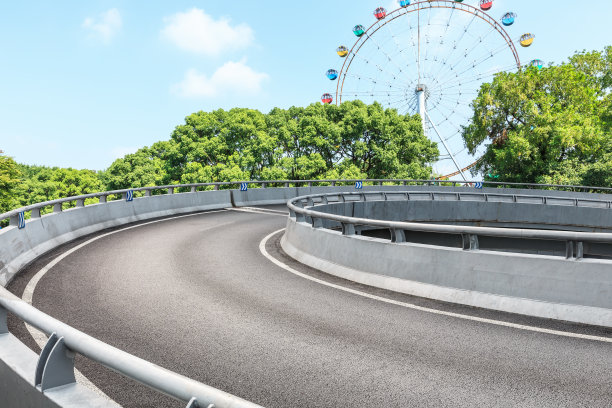 柏油路和摩天轮游乐场，城市公园里有绿树图片下载