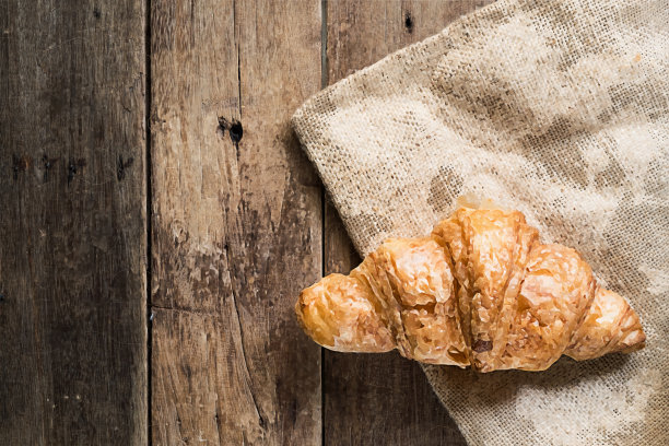 木桌上麻袋布上的新鲜牛角面包插图图片下载