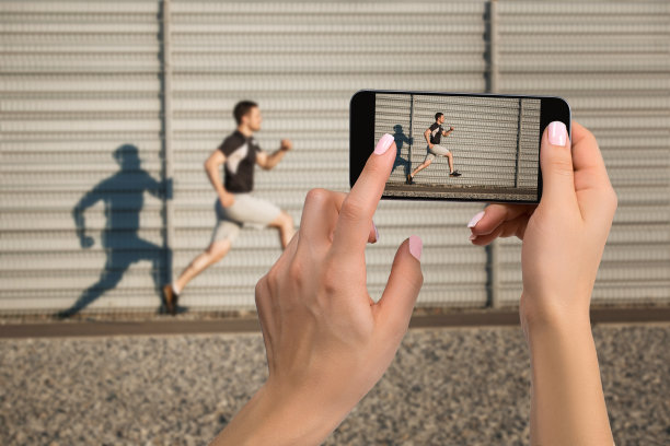 近距离拍摄女性手握手机的画面，屏幕上显示了拍照模式。运动员跑步的裁剪图像图片下载