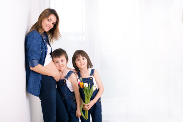 孕妇拥抱孩子，收到节日郁金香花，逆光图片下载