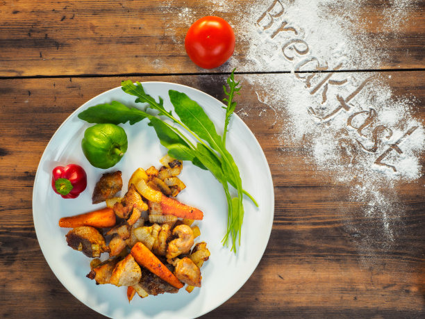 烤土豆，肉和莴苣放在一个白色的盘子里，俯视图。老木头背景下的蔬菜静物画。乡村早餐有土豆，辣椒，红辣椒，西红柿。水平的照片图片下载