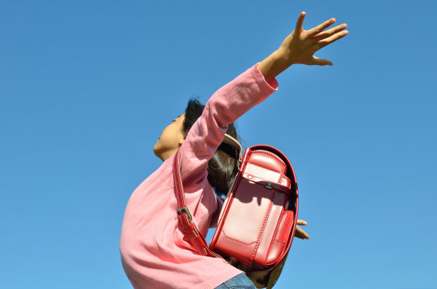 女孩们在蓝天上举手(侧视图)图片下载