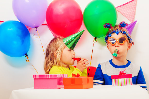 快乐的小女孩和男孩在生日聚会上拿着礼物图片下载