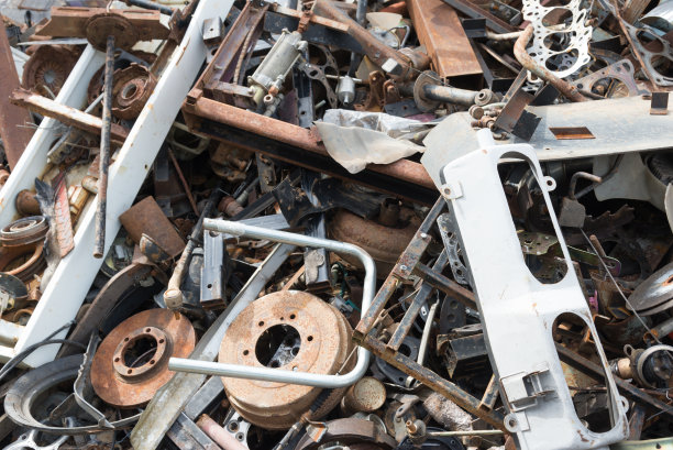 旧的生锈的汽车零件在汽车报废场。汽车回收。拆卸机械部件等待再利用或作为维修部件。图片下载