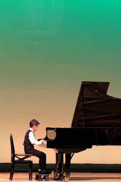 日本男孩在舞台上弹钢琴(小学二年级)图片下载