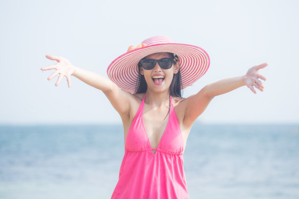 美丽的女人的肖像与迷人的微笑在海滩摆姿势，人与夏天的概念。复古的基调。图片下载