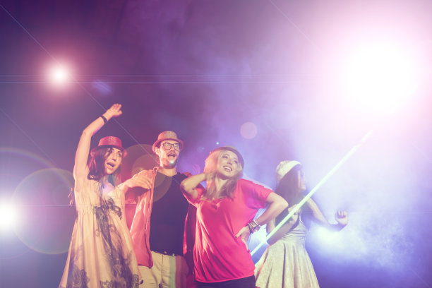 新年聚会，假期，庆祝，夜生活和人的概念-年轻人有乐趣跳舞在一个聚会。图片下载