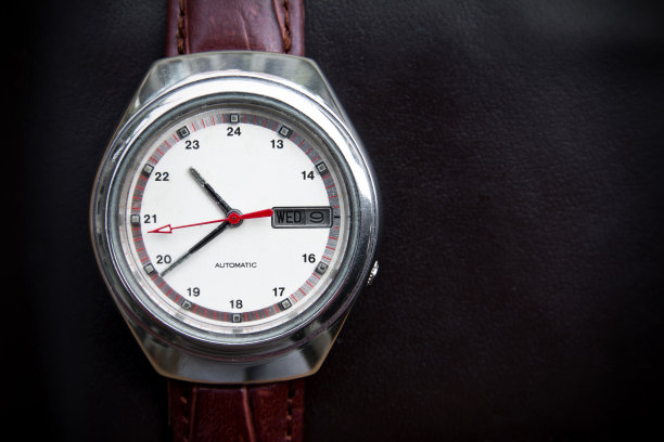 复古男士腕表上的黑色皮革背景。复古手表图片下载
