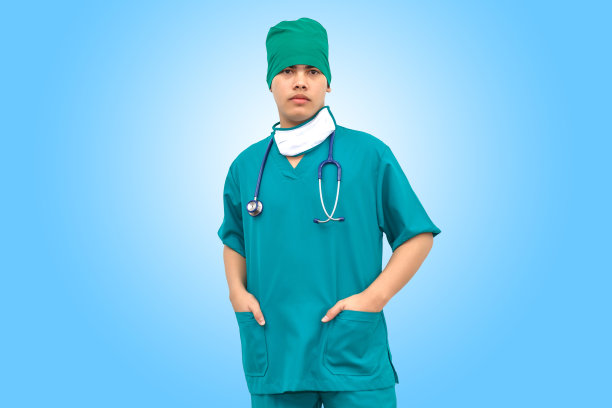 亚洲聪明的医生穿着绿色制服和医疗面罩与听诊器。孤立在蓝色背景。图片下载