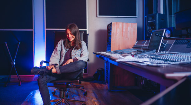 微笑的年轻女子音乐作曲家在录音棚图片下载