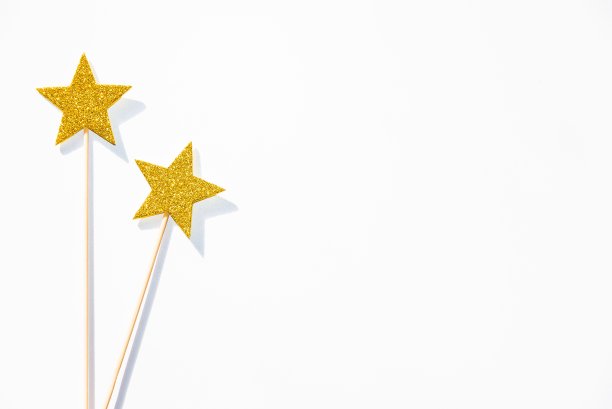 白色背景上的两根金色的派对魔术棒。副本的空间。图片下载