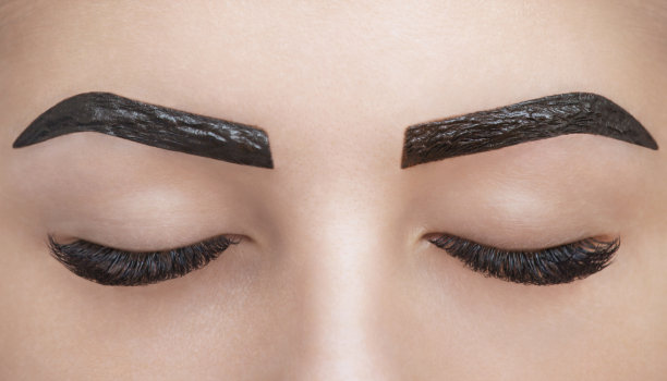 化妆师在美容院为眉毛涂指甲花图片下载