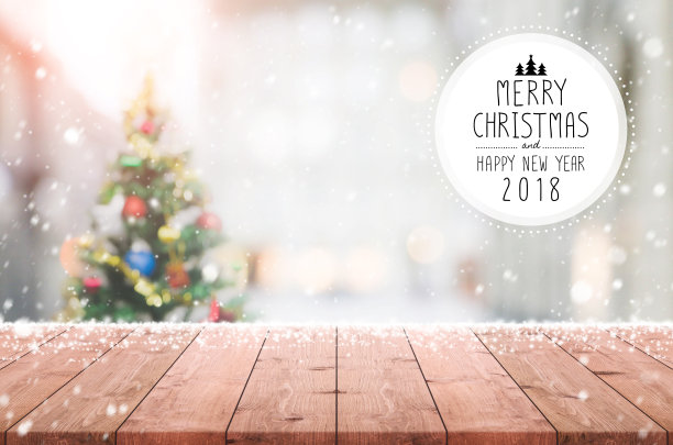 木质桌面模糊与散景圣诞树背景与雪花和圣诞快乐和新年快乐2018标志-可以用于展示或蒙太奇您的产品。图片下载