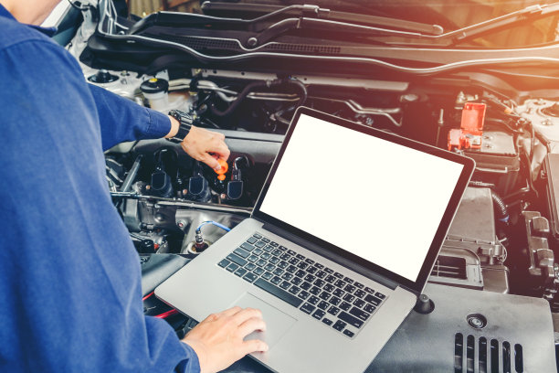 专业的汽车技师在汽车维修服务中使用笔记本电脑素材图片