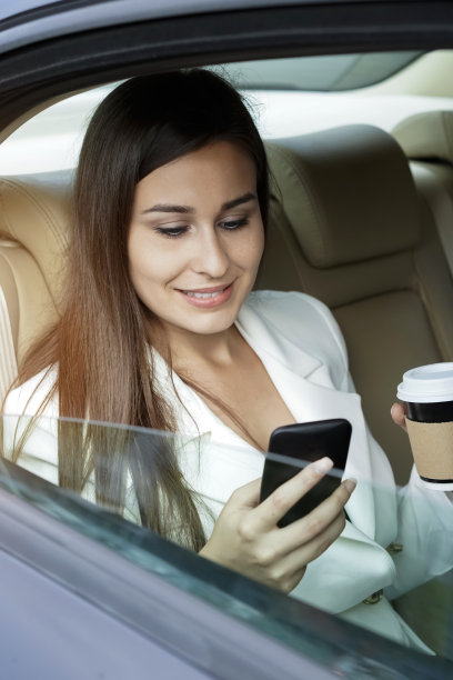 年轻的女商人坐在车里工作图片下载