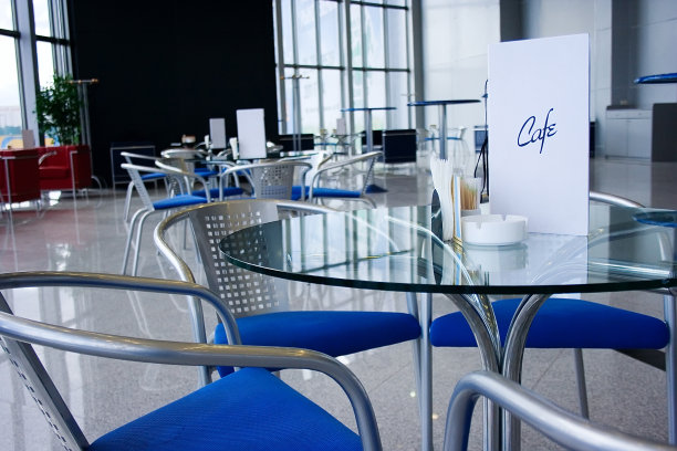 现代的咖啡馆内部有玻璃桌子，大窗户，石头地板和反射。图片下载