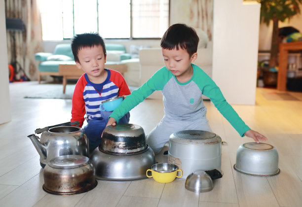两个兄弟在地板上玩着锅碗瓢盆图片下载